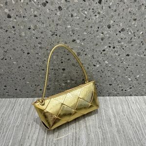 Detail shot of the gold woven leather texture and knot design on this square handbag