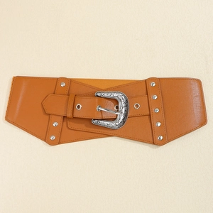 Detail of brown PU leather wide belt with silver vintage floral buckle and rivet accents
