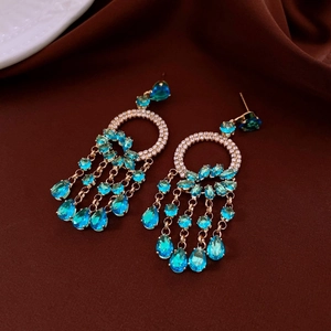 Detail of water drop blue crystal tassel earrings with sparkling rhinestones in gold