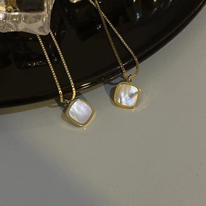 Close-up of golden square necklace featuring natural white mother-of-pearl inlay