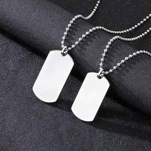 Polished silver stainless steel military dog tag necklace set on black textured surface