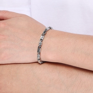 Detail view of silver industrial gear link chain bracelet on male wrist in stainless steel
