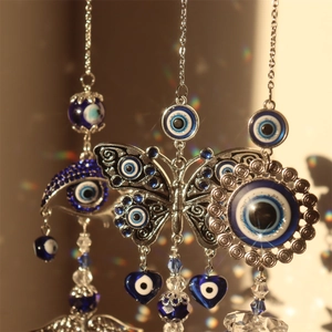 Close-up of hanging crystal suncatchers with blue evil eye beads and metal butterfly detail