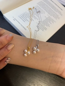 Detailed macro of gold and silver pearl necklaces with zircon stones on a book