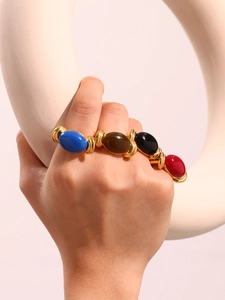 Close-up of golden multi-gemstone open ring with colorful oval resin stones on model's hand