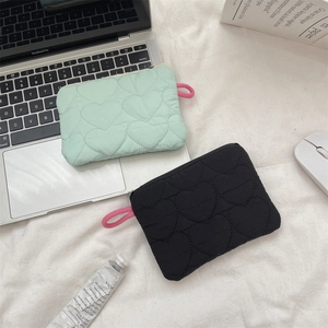 Quilted heart-shaped coin purse in mint green and black with pink zippers and metal rings