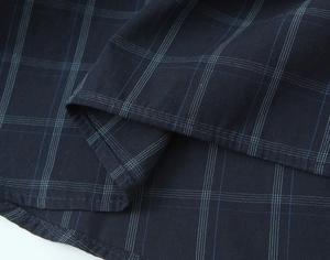 Detail view of navy blue plaid poplin fabric showing stitching and soft texture