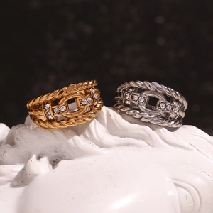 Detail of twisted chain rings in 18K gold and silver finish with sparkling zircons