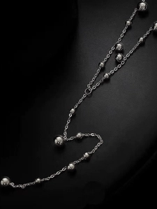 Macro shot of silver beaded long tassel necklace with polished metallic sphere details