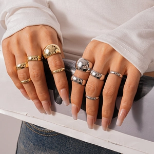 Detailed view of polished geometric gold and silver rings stacked on fingers