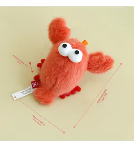 Detail showing plush lobster catnip toy with orange strap and soft red fabric texture