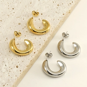 Polished C-shape stainless steel earrings in gold and silver finish on stone display