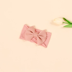 Close-up of soft dusty pink nylon baby headband featuring a large 3D textured bow design