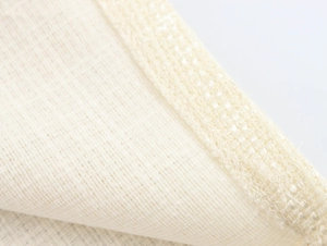 Gros plan sur la texture du tissu en tweed beige avec tissage en maille et surjet précis