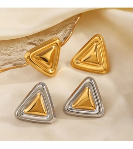 Détails de boucles d'oreilles géométriques triangulaires en or et bicolore sur soie