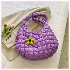 Detail of purple quilted cloud tote bag texture with yellow sunflower plush charm
