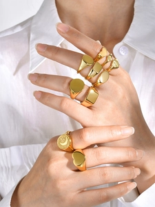 Close-up of assorted gold signet rings set with celestial engraving on hand