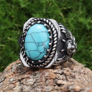 Detailed view of an eagle motif stainless steel ring with a turquoise-colored stone