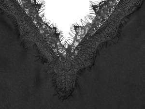 Detailed close-up of delicate lace trim on black satin dress with V-neckline