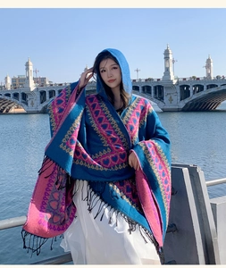 Detailed view of ethnic hooded shawl with pink heart patterns and tassels for travel