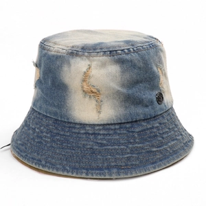 Detail of distressed denim bucket hat with frayed holes and parallel stitching