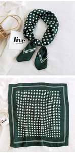 Detail of dark green polka dot silk square scarf styled with a white shirt and straw bag