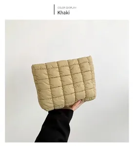 Detailed macro view of khaki quilted cotton handbag texture with square padded pattern