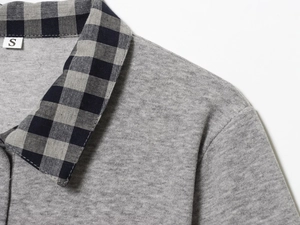 Detail shot of the grey knit polo top showing the plaid collar and size S woven label