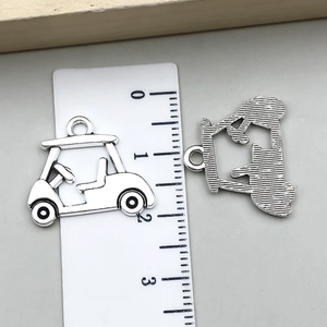 Mesure de la taille des pendentifs voiture de golf et golfeur en métal avec une règle