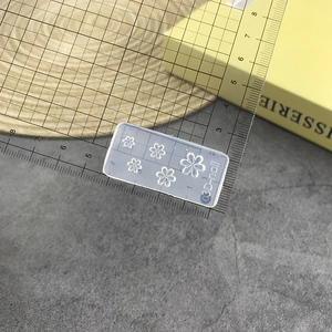 Detailed view of 3D silicone nail mold with rose patterns on a scale for size measurement