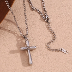 Detailed macro shot of silver stainless steel cross pendant with figaro chain texture