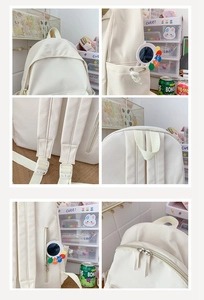 Detail view of beige nylon backpack features adjustable straps and reinforced top handle