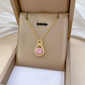 Detail shot of a pink water drop pendant necklace with diamonds on white silk