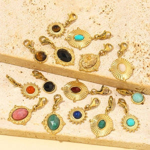 Gold stainless steel pendants with natural gemstones and lobster clasps on stone