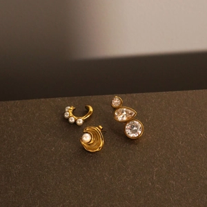 Macro shot of gold-plated earring set with white pearls and clear zircon crystals