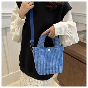 Blue corduroy tote bag detail showing pleated handle and adjustable fabric shoulder strap