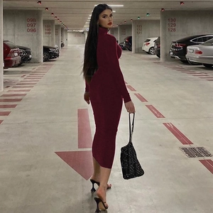 Detailed close-up of wine red slim-fit turtleneck dress with long sleeves in knit fabric