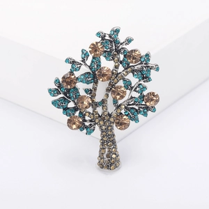 Macro detail of Tree of Life brooch with teal rhinestones and golden faceted gems