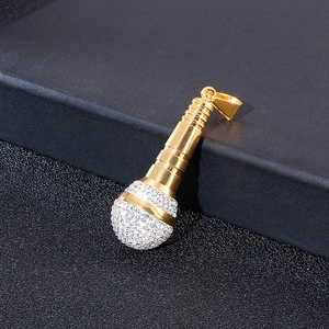 Pendaglio microfono dorato hip hop con strass brillanti su una superficie scura