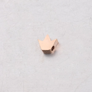 Vue détaillée d'une perle couronne en or rose avec un petit trou pour la création de bijoux