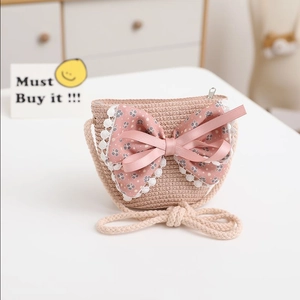 Detail of girls straw crossbody bag with floral bow and delicate lace trim accents