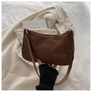 Detailed view of brown woven texture fabric and PU leather strap on shoulder bag