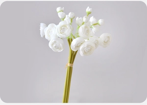 Detail of white artificial ranunculus bouquet with lifelike petals and green buds