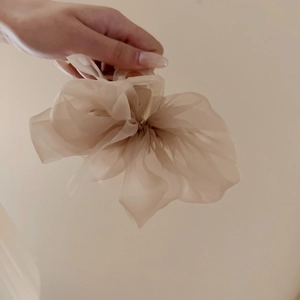 Close-up of a delicate beige organza hair scrunchie with soft chiffon texture