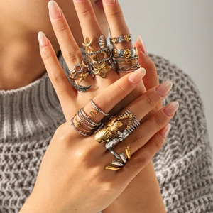 Detail view of model wearing gold and silver mixed stacking rings with sea shells and stars