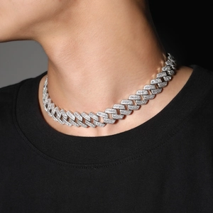 Close-up of 20mm silver Cuban link necklace with pavé zircon stones on a male model