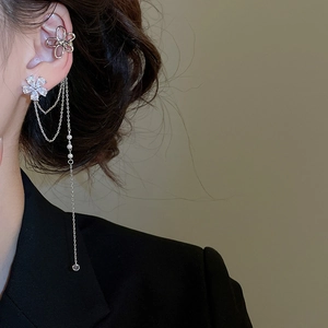 Gros plan détaillé d'un earcuff floral argenté avec de longs pompons et zircons