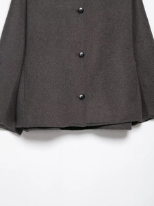 Detailed view of the dark grey faux fur jacket hem featuring three black buttons