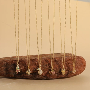 14K gold plated necklaces with various shell, cherry and lemon pendants on wood
