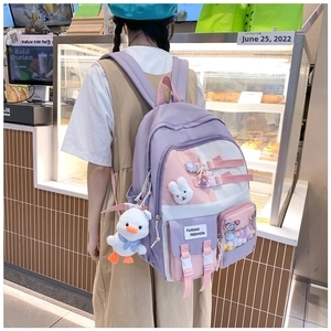Close-up of pastel patchwork school backpack with cute plush charms and functional pockets